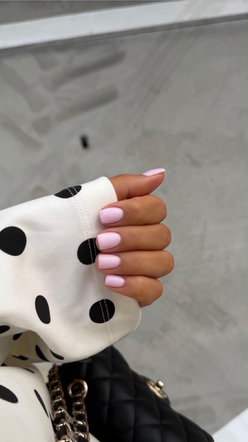Roze BIAB-nagels bij een gestippelde witte mouw